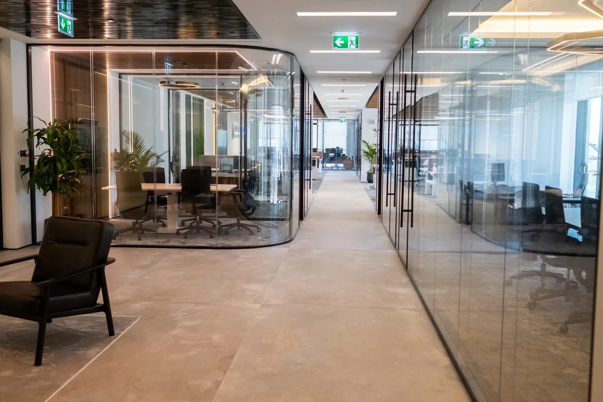 Glass offices along the corridor, the IMI at One Za’abeel office fitout by Fajr Interiors