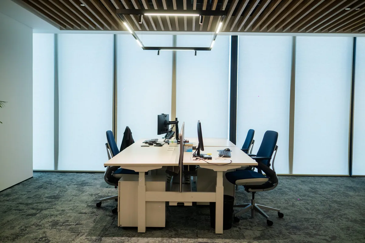 Workstations under a timber-slatted ceiling, the IMI at One Za’abeel office fitout by Fajr Interiors