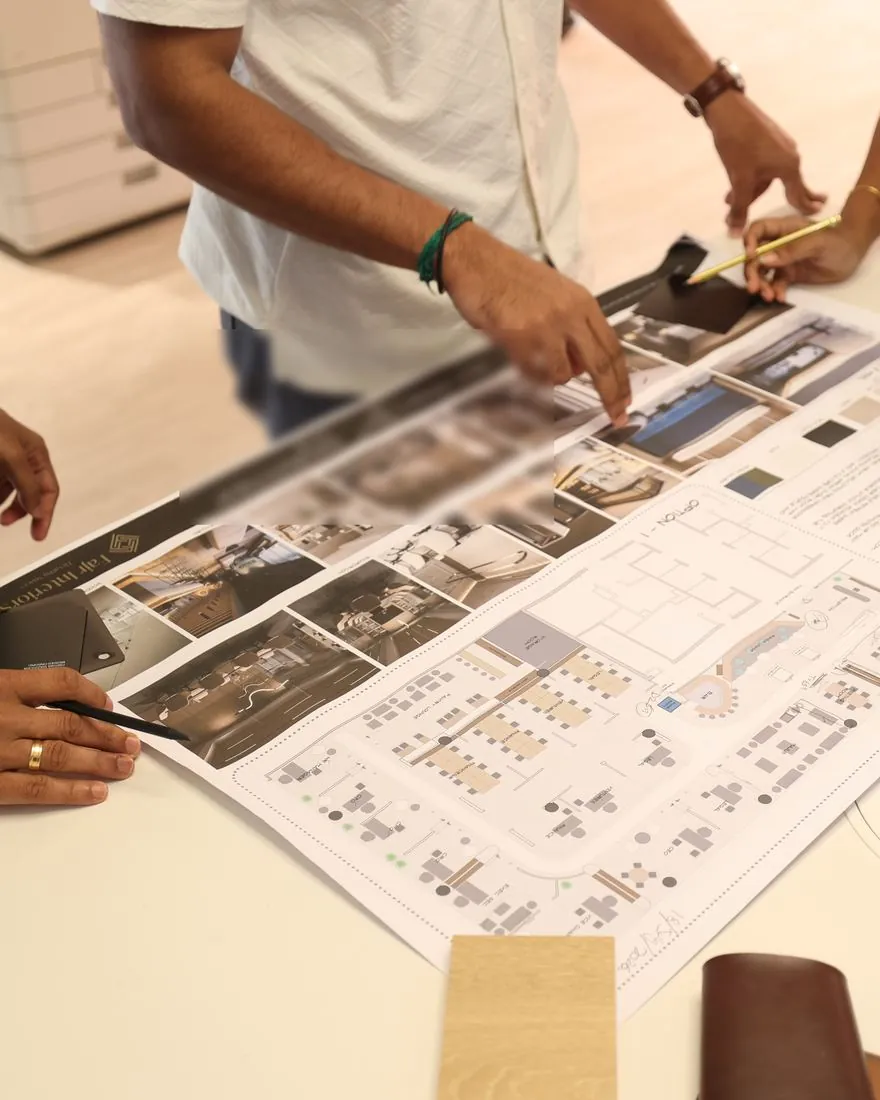 Fajr designers reviewing a concept board, floor plan and material samples on the studio table
