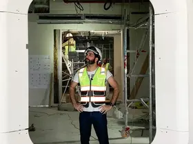 Fajr Interiors founder on site in a hard hat and hi-vis vest, build stage