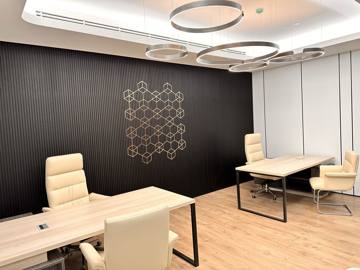 Executive office at Crypto One: a pale timber desk and chairs against a black slatted wall with a brass motif