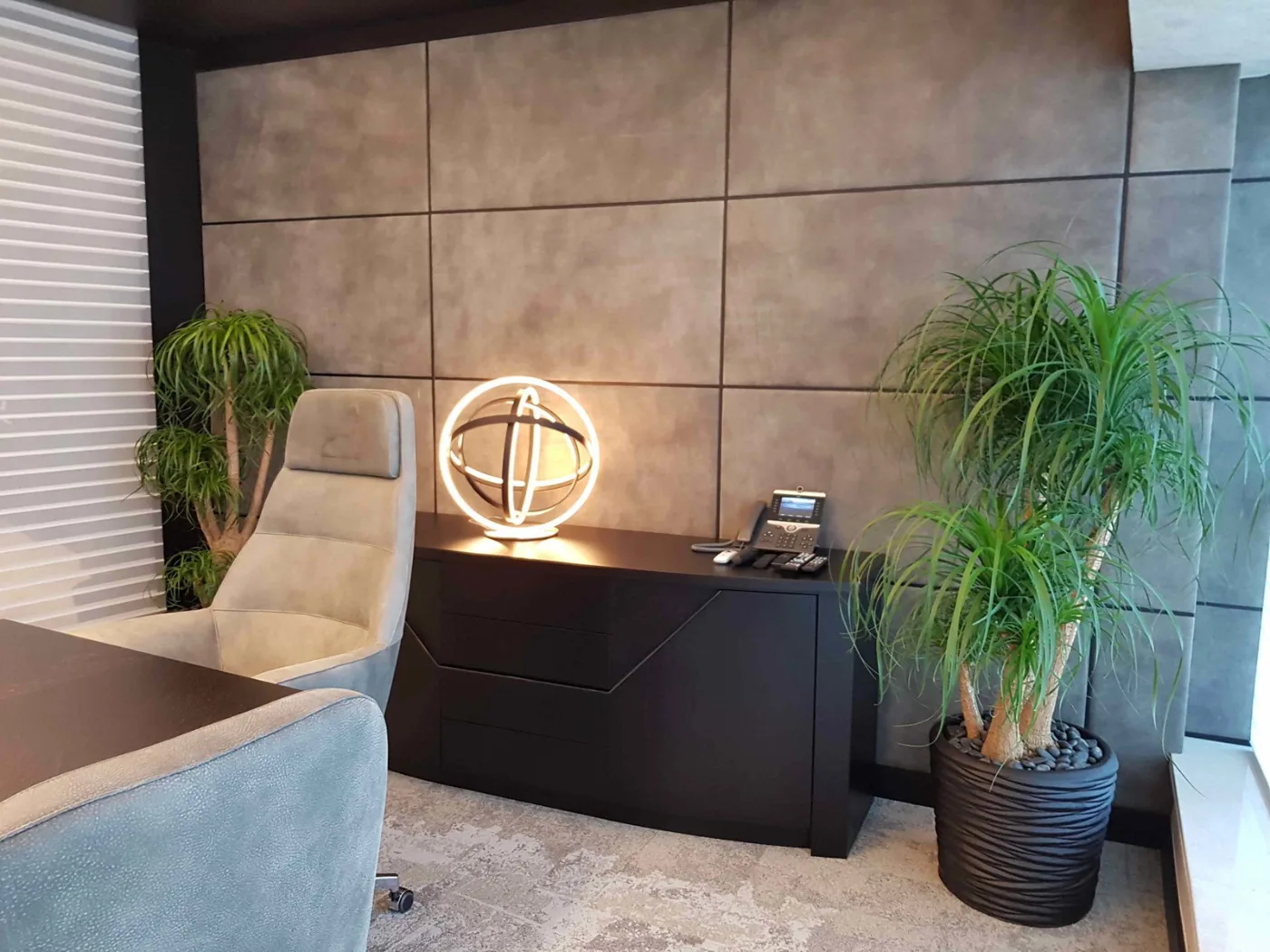 Executive office credenza against a stone-panel wall with a lit sculpture and planting, delivered by Fajr Interiors for ASI, Dubai
