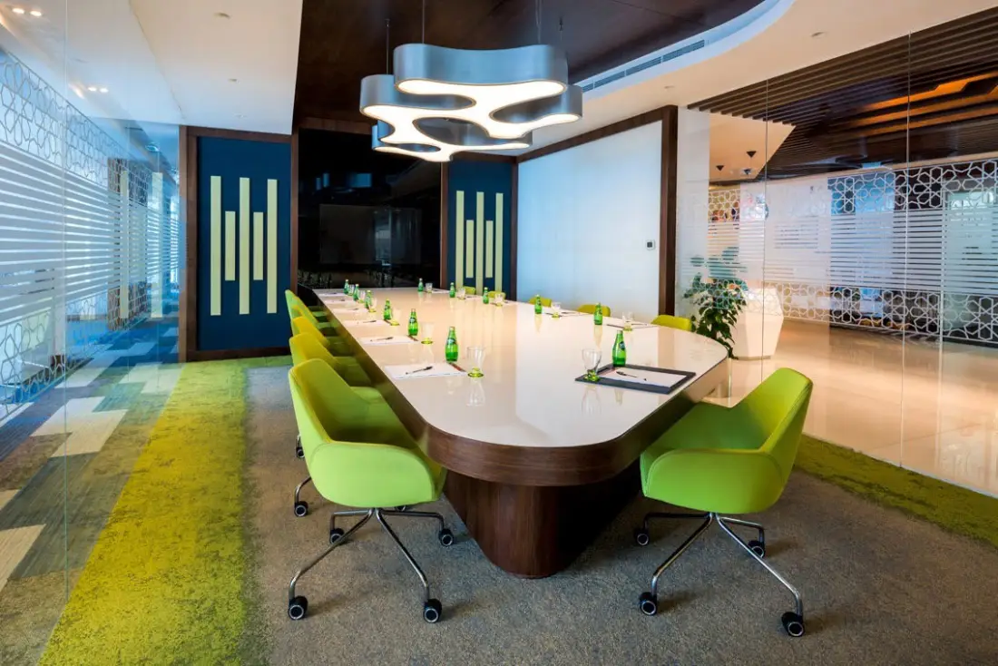 Boardroom with a long white table and green chairs, Serene office, Vision Tower, Dubai