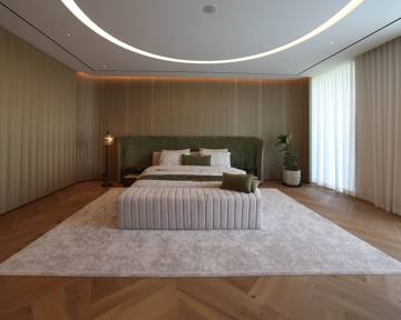 Principal bedroom at Villa 47 Fairways: an upholstered headwall, cove-lit ceiling and herringbone floor