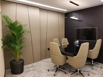 Meeting room with upholstered wall panels, linear lighting and a dark feature wall, ASI office, Dubai