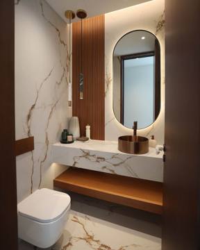 Powder room at Villa 47 Fairways: an oval lit mirror, walnut panel and floating marble vanity