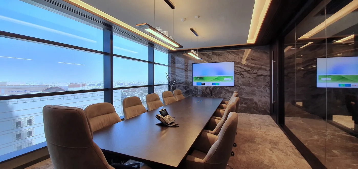 Boardroom with a long table and a full-height city view, delivered by Fajr Interiors for AlSubeai Investments, Jeddah