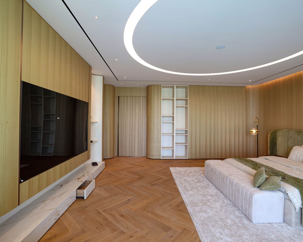 Fajr joinery in a finished bedroom: timber wall panelling, a media wall and built-in wardrobes