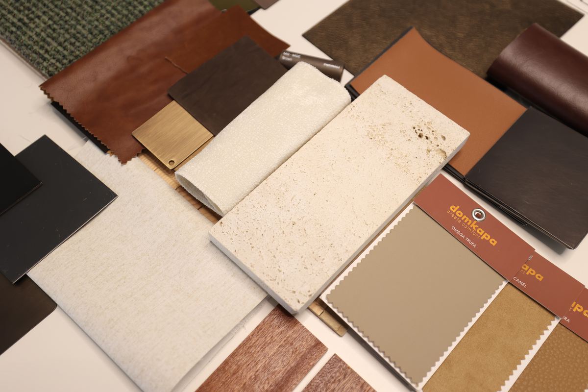 Stone, veneer, leather and fabric samples laid out on the studio table at Fajr Interiors