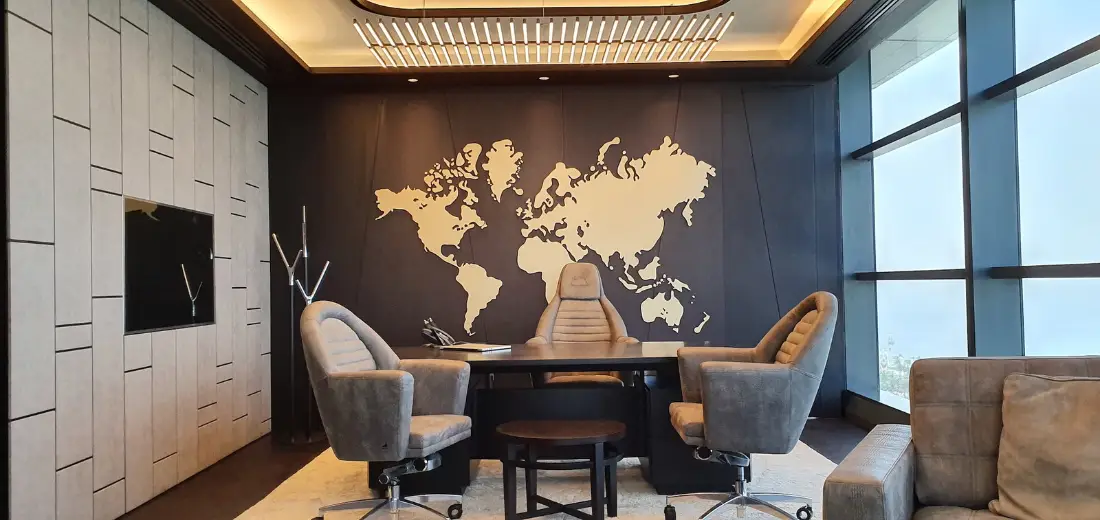 Executive office with a world-map feature wall and city-view glazing, delivered by Fajr Interiors for AlSubeai Investments, Jeddah
