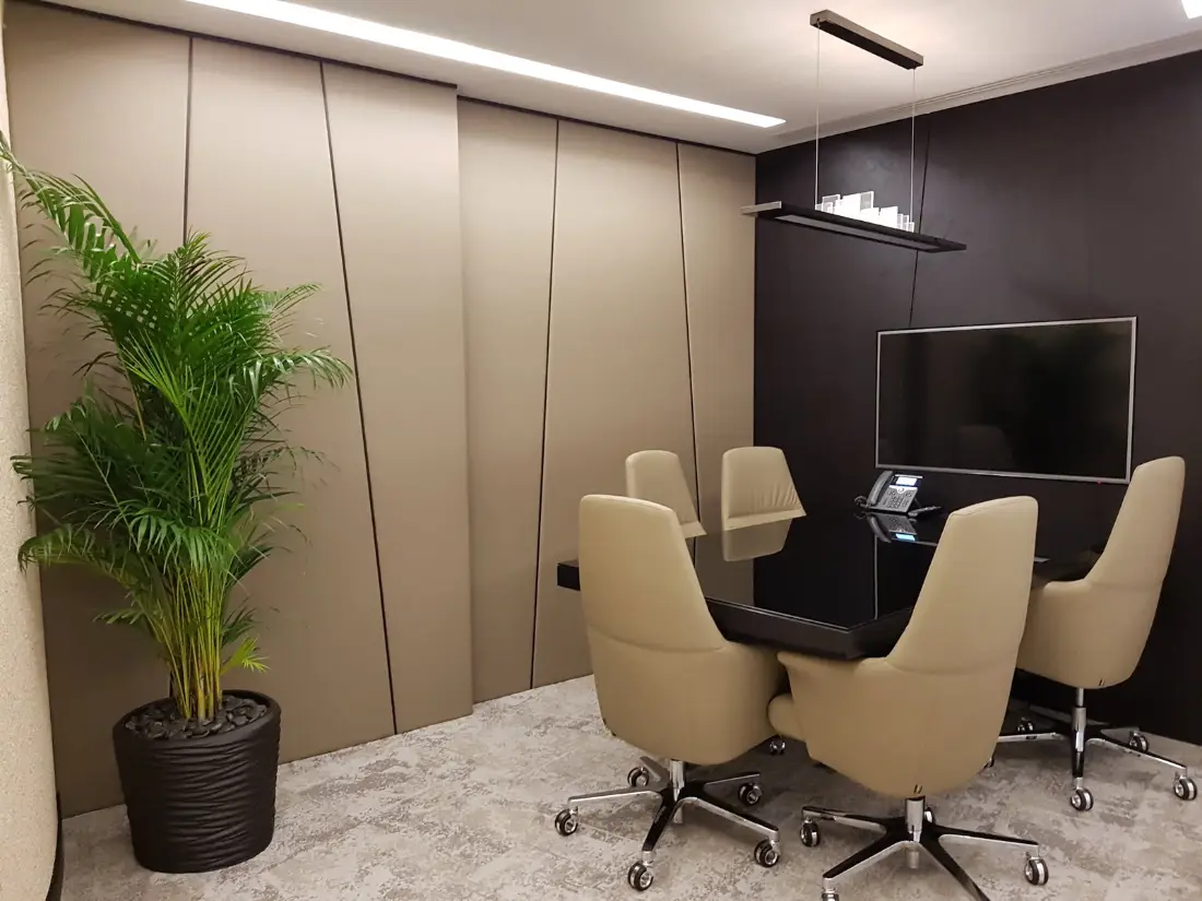 Meeting room with upholstered wall panels, linear lighting and a dark feature wall, ASI office, Dubai