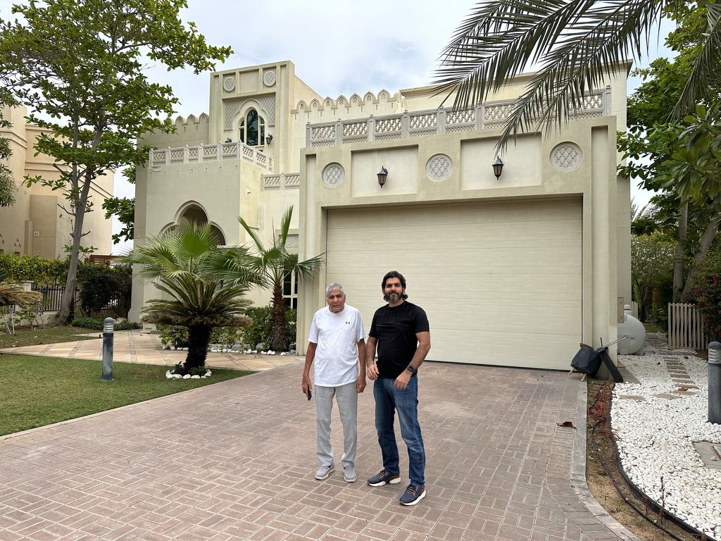 A villa owner with the Fajr team outside the villa before its remodel