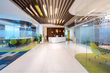 Reception at Serene, Vision Tower: a white reception desk under timber ceiling slats, glass meeting rooms beyond, Dubai