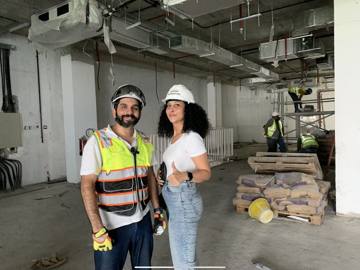 The Fajr site engineer and the client on the Crypto One floor during the fit-out, workers behind