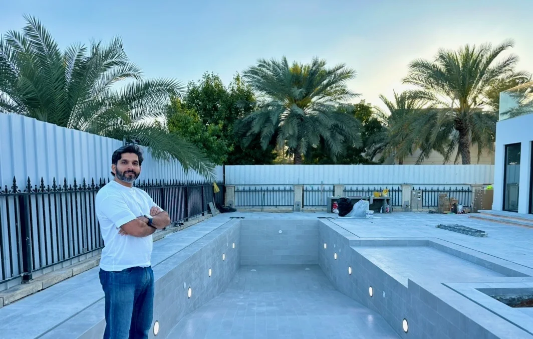 Photo: the same pool, tiled, with its lights fitted and a man in a white T-shirt standing beside it, Cluster 39, Villa 1, Jumeirah Islands