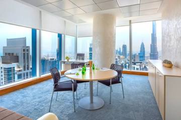 Meeting room with a round table and a view over the Sheikh Zayed Road towers, Serene office, Vision Tower, Dubai