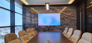 Boardroom with a stone wall and a presentation screen, delivered by Fajr Interiors for AlSubeai, Dubai
