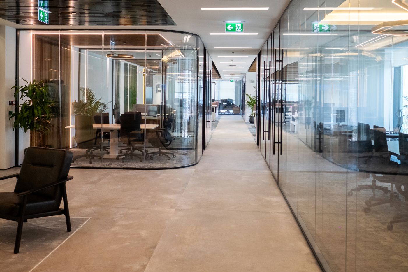 IMI office at One Za’abeel: curved glass meeting room beside the main corridor