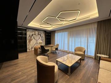Executive lounge at Crypto One: leather armchairs and a marble table under a geometric light