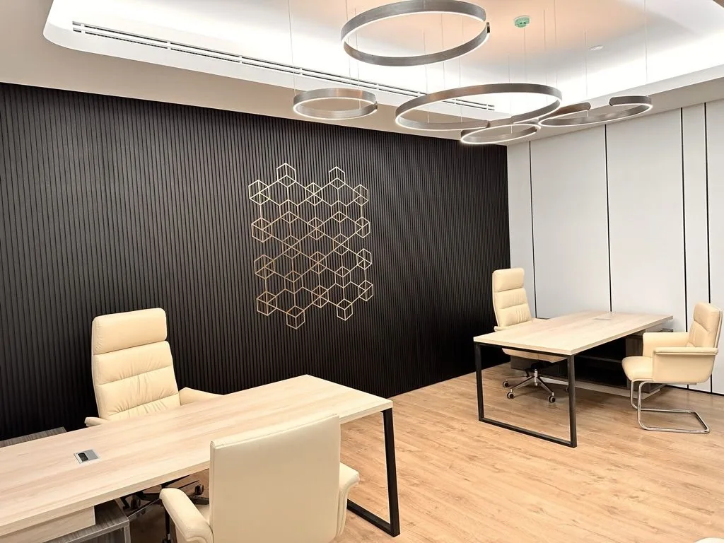 Executive office at Crypto One: a pale timber desk and chairs against a black slatted wall