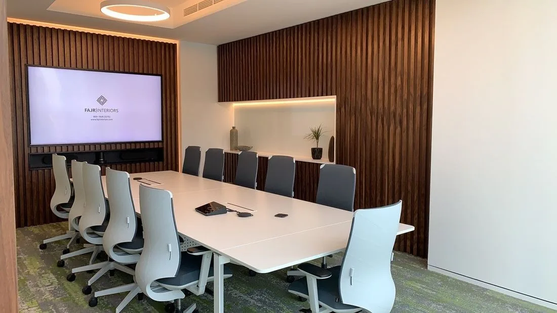Meeting room at International Materials, Opus by Omniyat: a white table, timber-slatted walls and a screen