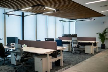 Photograph: sit-stand desks under the timber ceiling, the IMI at One Za'abeel office fitout by Fajr Interiors