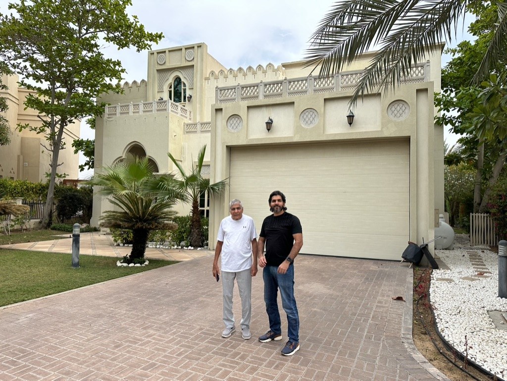 Photo: the front of the villa before the works, its garage and paved driveway, two people standing on the drive, Cluster 39, Villa 1, Jumeirah Islands